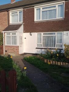 a house with white windows and flowers in the yard at 3BR House with garden near Bicester Village in Bicester