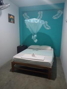 a bedroom with a bed with a blue wall at La posada del amor in Máncora