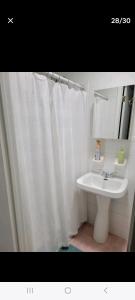 a bathroom with a sink and a white shower curtain at Private apartment, NOT SHARED, Near public transportation, SUPER fast free WIFI, Due to NY restrictions it can only be booked for 30 nights or more, even if the site allows you to book it, I WILL NOT be able to accept the reservation, 30 NIGHTS MINIMUM in Hunts Point