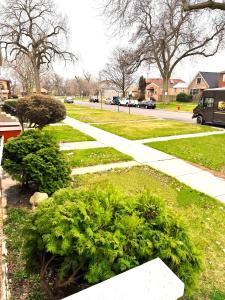 a walkway in a park with bushes and trees at Fully Equipped Cozy 4/5 BR in Chicago