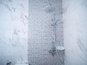 una ducha en un baño con una pared de azulejos en KEUR YAYE FA, en Dakar