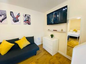 un soggiorno con divano blu e TV di Luton Luxury Apartment a Luton