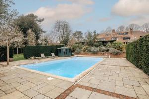 una piscina en un patio con una casa en Summer Gaze House, en Harpsden