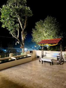 a park with a bench and a gazebo at night at EMINENCE - PALM RESIDENCY (1.5 KM FROM NAKKI LAKE) in Mount Ābu