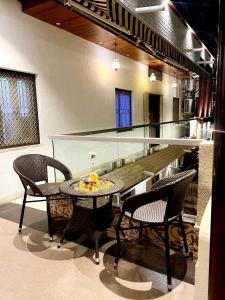 a dining room with a glass table and chairs at EMINENCE - PALM RESIDENCY (1.5 KM FROM NAKKI LAKE) in Mount Ābu