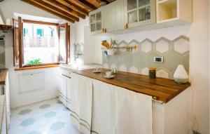 une cuisine avec des placards blancs et un comptoir en bois dans l'établissement Pet Friendly Apartment In C, Val Di Cecina With Kitchen, à Castelnuovo di Val di Cecina