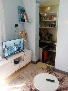 a living room with a flat screen tv on a cabinet at Runda UN Gigiri - kikao private cottage in Nairobi