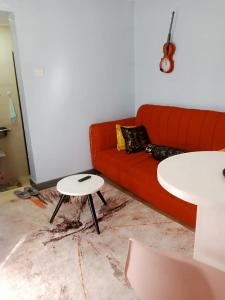 a living room with a red couch and a table at Runda UN Gigiri - kikao private cottage in Nairobi