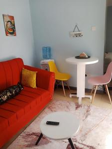 a living room with a red couch and a table at Runda UN Gigiri - kikao private cottage in Nairobi