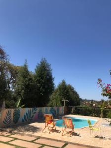 a group of chairs sitting around a swimming pool at casa rústica e aconchegante in Analândia