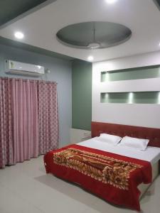 a bedroom with a large bed with a red blanket at Hotel New Food Restrorent in Ujjain
