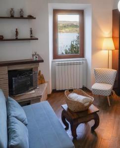 sala de estar con sofá y ventana en Le Rupi - Apartment en Anguillara Sabazia