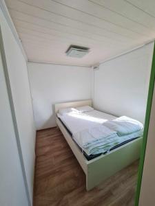 Habitación blanca pequeña con cama. en Hiška Panonski gaj - Terme Banovci en Veržej