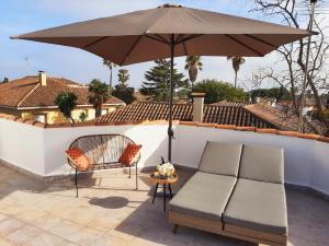 a patio with a couch and an umbrella at Villa Cambrils Mar in Cambrils