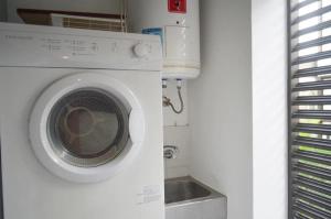 een wasmachine in een keuken met een wastafel bij Barranco Cozy Apartment in Lima