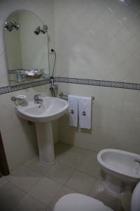 uma casa de banho com um lavatório, um WC e um espelho. em Casa de Sao Cristovao em Boticas