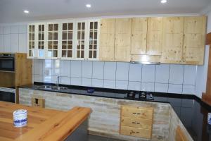 a kitchen with wooden cabinets and a wooden counter top at Moreira Estates in Vila do Maio