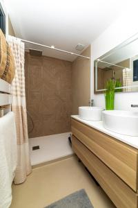 een badkamer met 2 wastafels en een douche bij VILLA au Bord du Lac de Sanguinet in Sanguinet