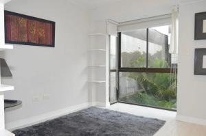 een woonkamer met een groot raam en een tapijt bij Barranco Cozy Apartment in Lima