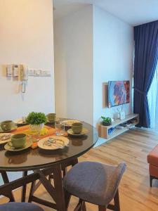 sala de estar con mesa con sillas y TV en Hann's Residence Homestay City View 2R2B, en Sibu