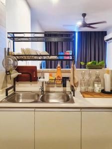 cocina con fregadero y estante con botellas en Hann's Residence Homestay City View 2R2B, en Sibu