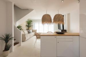uma cozinha com armários brancos e uma sala de estar em Modern Retreat: 3 Bedroom Villa in the Old Village em Quarteira