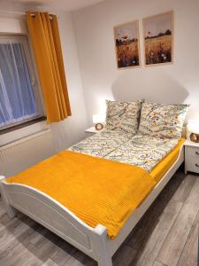 a bedroom with a bed with a yellow blanket at Ferienwohnung Wolin Ostsee Insel Misdroy in Wolin