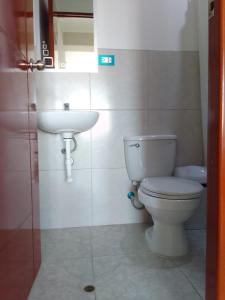 a bathroom with a toilet and a sink at Hostal Tulipán Rojo in Lambayeque