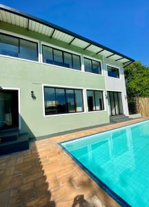 una casa con piscina delante en Suítes Por do Sol, en Cabreúva