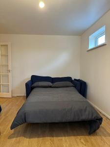 a bedroom with a blue bed in a room at Specious 1 Bed Apartment free wifi and parking in Goodmayes