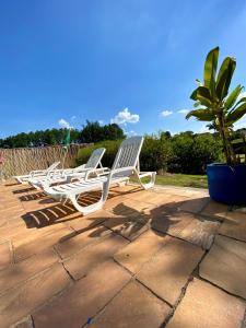 Una fila de sillas de jardín en un patio. en Suítes Por do Sol, en Cabreúva