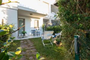 un jardín con una silla y una mesa en el patio en Villaggio Evanike, en Bibione