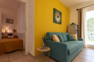 sala de estar con sofá azul y pared amarilla en Villaggio Evanike, en Bibione