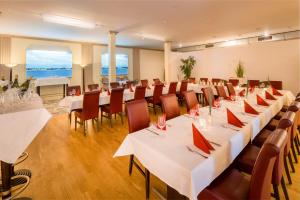 a large room with tables and chairs with white tablecloths at Villa Beachside in Eckernförde +50 photos