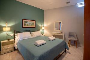 a bedroom with a bed with two towels on it at House Aggeliki Private Hot Tub in Kissós