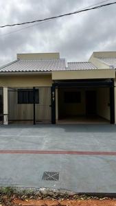 a house with a garage with a driveway at Casa da Estadia Tranquila. in Dourados