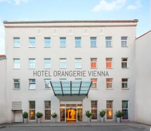 ein weißes Gebäude mit einem Schild, das das Hotel oder die Unterkunft vienna liest in der Unterkunft Hotel Orangerie in Wien