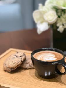 uma chávena de café e uma bolacha na mesa em Platinum Hotel em Iambo