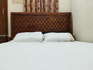 a bed with two white pillows in a room at New Hotel Labbaik 3 in Dhaka