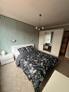 a bedroom with a bed with a black blanket and a mirror at La Terasse des Vignes - Maison 2 Chambres - 4 Personnes in Blienschwiller