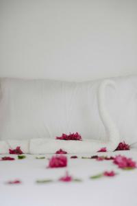 a white bed with pink flowers on it at Nungwi 14 bnb in Nungwi