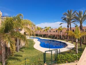 a swimming pool in a resort with palm trees at roomwithview casa marco in Mojácar