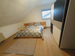 a bedroom with a bed and a window in a attic at Ferienwohnung Haßberge in Knetzgau