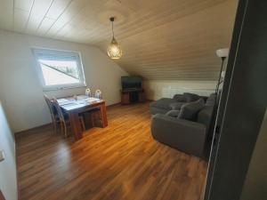 a living room with a couch and a table at Ferienwohnung Haßberge in Knetzgau