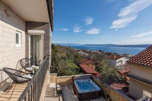- un balcon avec vue sur une maison dotée d'un bain à remous dans l'établissement House Roko, à Dramalj
