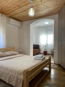 a bedroom with a large bed with a wooden ceiling at Villa Kroi in Berat