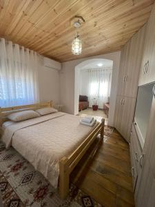 a bedroom with a large bed and a wooden ceiling at Villa Kroi in Berat