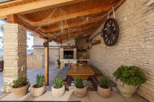 un patio con una mesa de madera y una pared de ladrillo en House Roko, en Dramalj