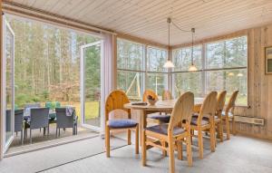 - une salle à manger avec une table, des chaises et des fenêtres dans l'établissement 3 Bedroom Lovely Home In Ans By, à Roe