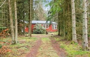une maison rouge au milieu d'une forêt dans l'établissement 3 Bedroom Lovely Home In Ans By, à Roe